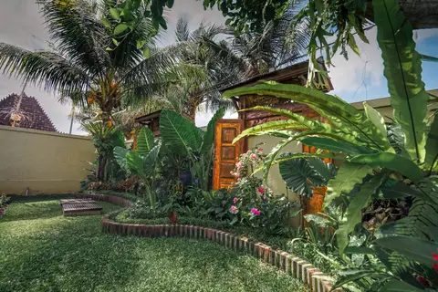 Rumah Elfi: garden with palm trees and a small shrine