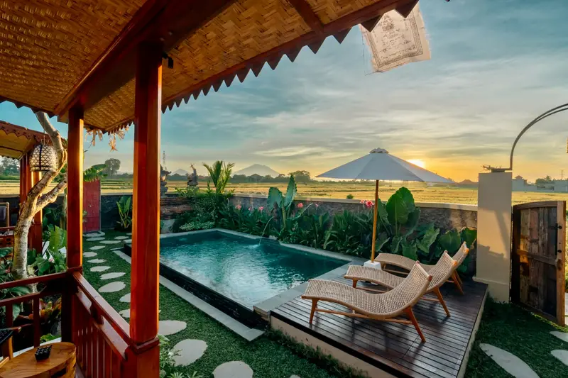 Joglo Hati: pool with sun loungers above the rice fields at sunset