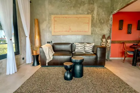 Joglo Hati: living room with a leather sofa and wall art