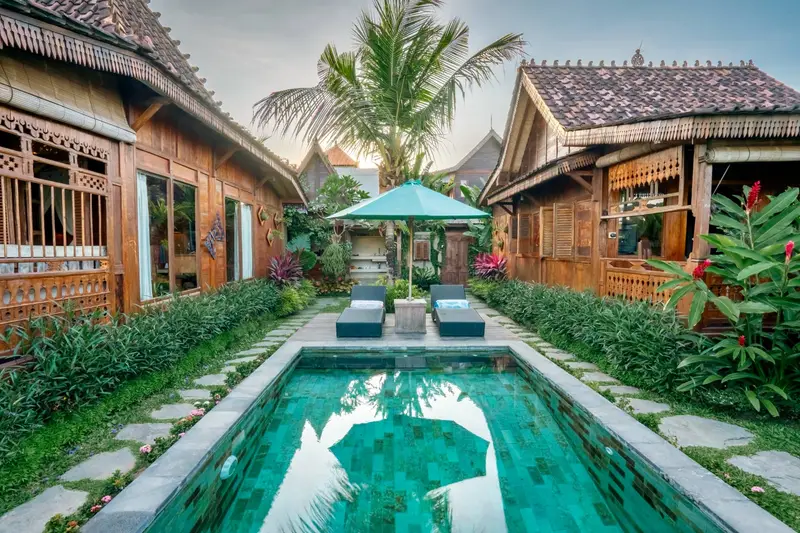 Rumah Richard: pool with sun loungers between the cottages