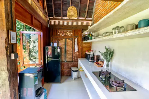 Rumah Richard: kitchen with a fridge and wooden cabinets