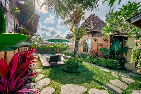 Rumah Richard: garden with red plants and the first cottage