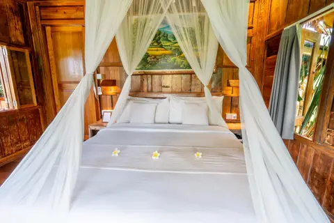 Rumah Richard: bed with fresh flowers in the second cottage