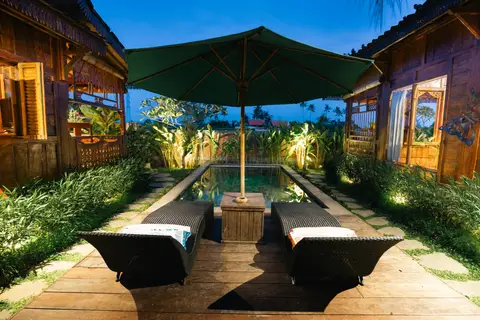 Rumah Richard: sun loungers by the lit pool at night